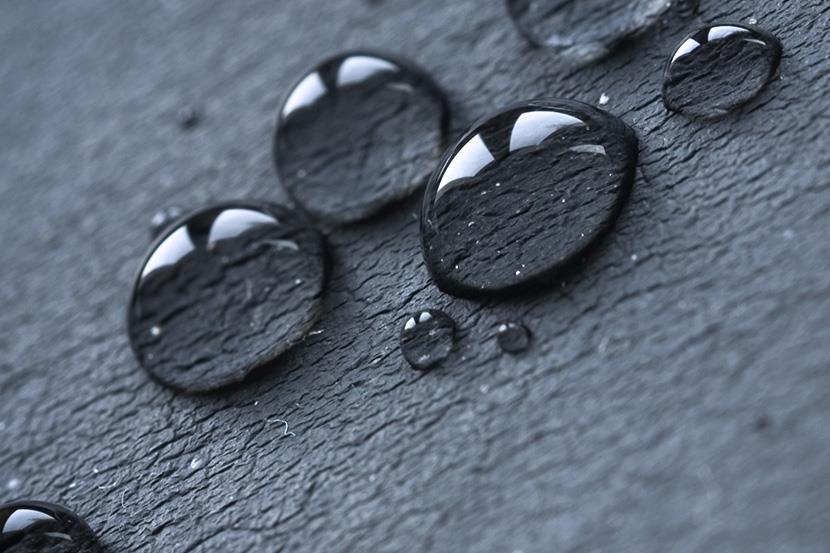 closeup of water droplets on black surface