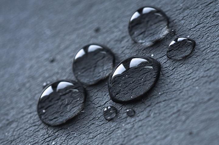 closeup of water droplets on black surface