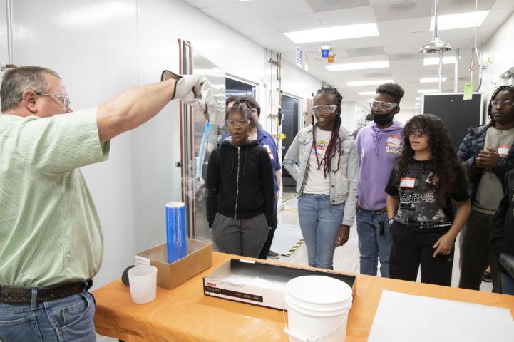 Students watching an experiment be performed