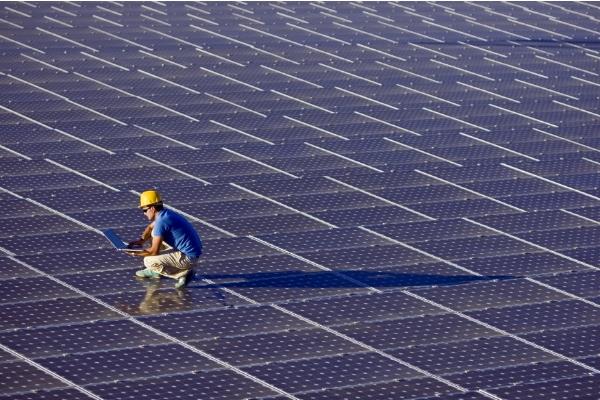 Mann arbeitet an einer Solaranlage