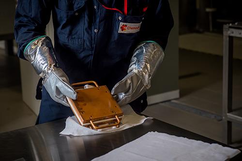Employee in safety gear holding a device