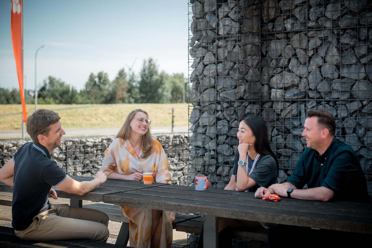 4 people sitting at a picnic table 