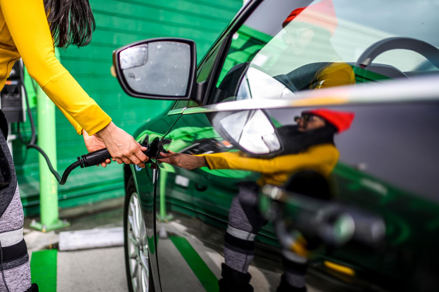 Person plugging car into charging station