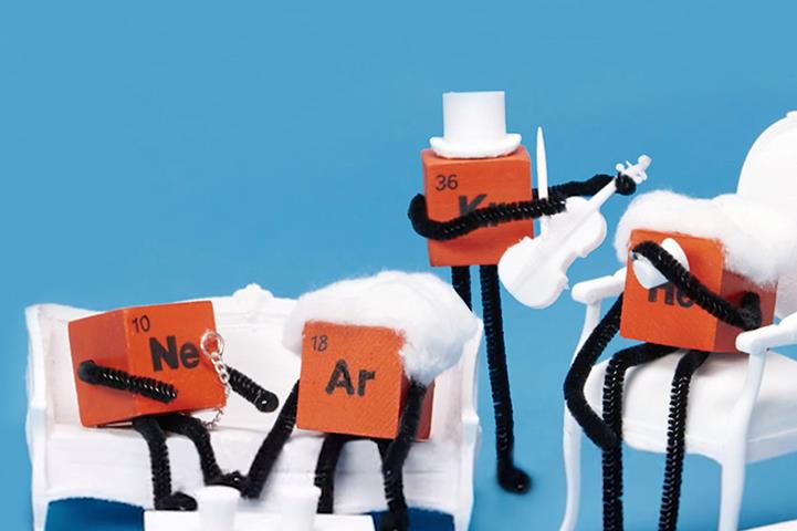 four small orange cubes with different elements painted on them in black spring arms
