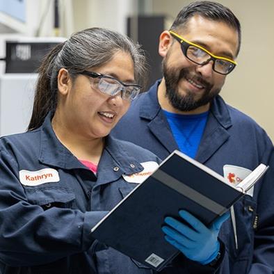 two people looking at a book in a lab