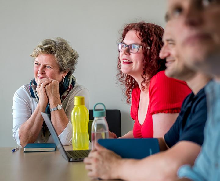 4 people sitting at a desk