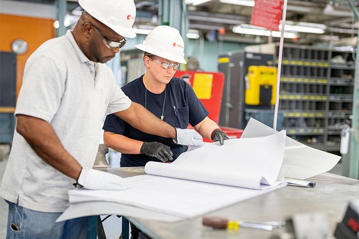 Two employees reviewing plans on a table