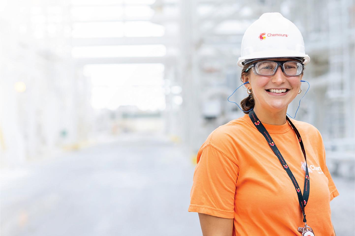 Employee standing outside with a hardhat and safety glasses
