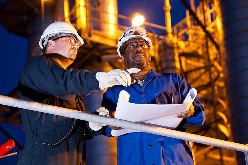 two chemical plant workers at night