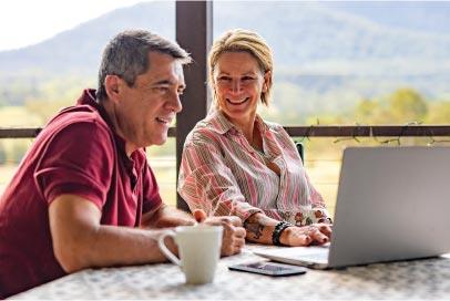 two people looking at a laptop and laughing